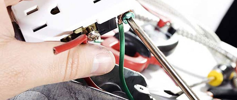 an electrician working on an electrical outlet